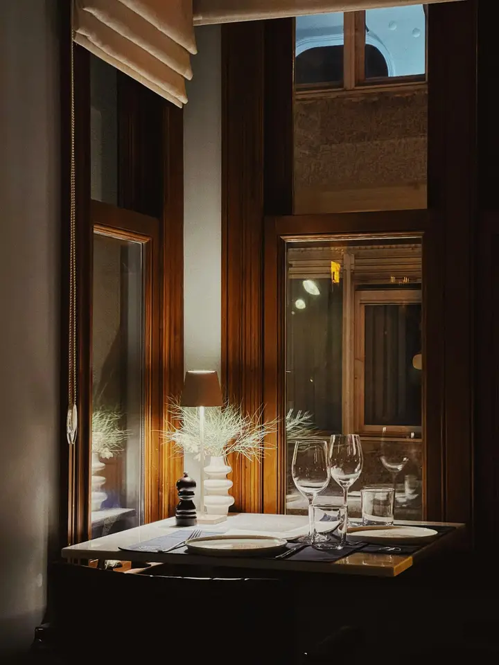 Mesa vestida junto a una ventana en penumbra